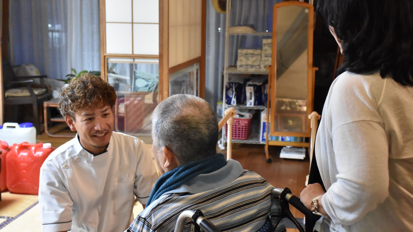 ご本人とご家族と一緒に、笑顔で話すセラピスト